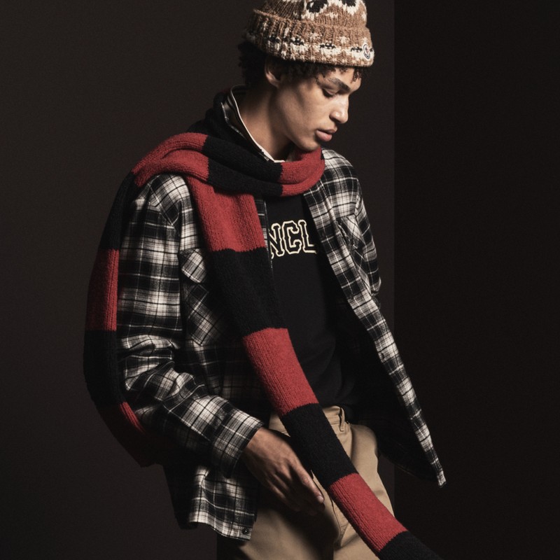 Moncler für Herren. Dunkelbraune Mütze, grauer Patchwork-Cardigan, schwarze Steppdaunenjacke, Karohemd und beige Hose (2). 