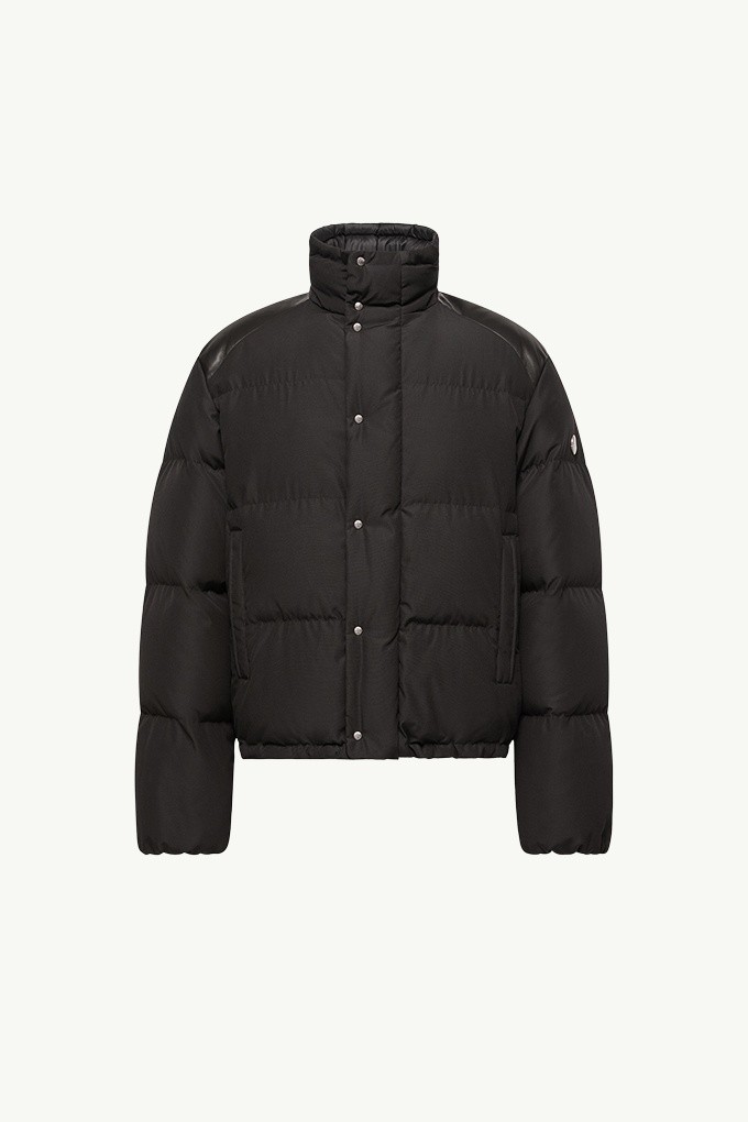 Moncler Re/Icons 2026, piumino corto Verone da uomo nero con collo alto e patch logo sulla manica.