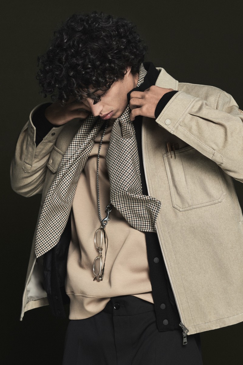 Moncler Pre-Fall 2026米色與黑色單品:鴨舌帽、襯衫外套、圍巾、麻花針織衫、長褲與短褲。