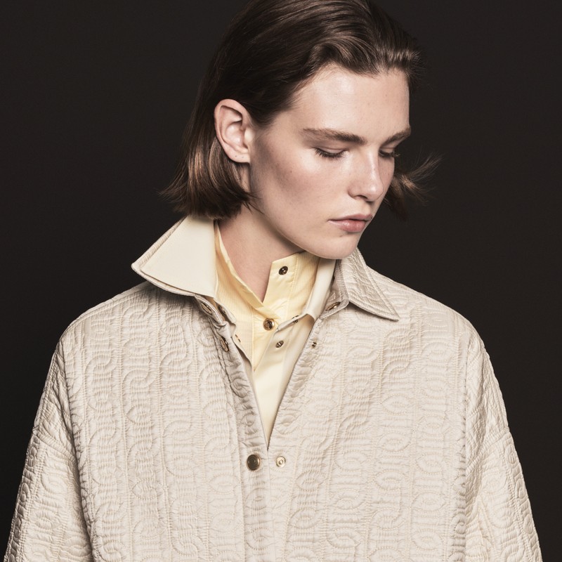 Outerwear Moncler pour femme. Surchemise matelassée crème à col haut sur chemise jaune pâle.