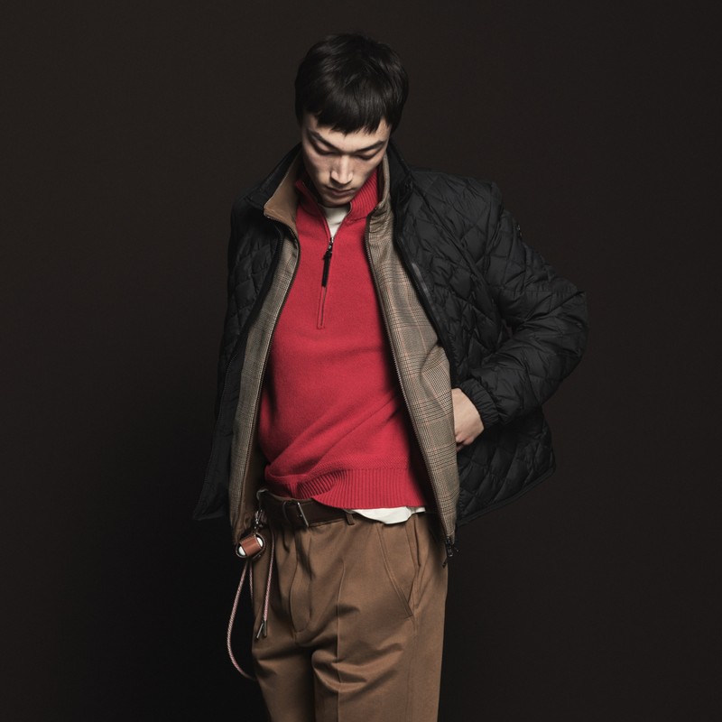 Black jacket, brown trousers, red sweater from the Moncler Pre-Fall 2026 for men; grey jacket, beige bag and shorts from the Moncler Pre-Fall 2026 for women.