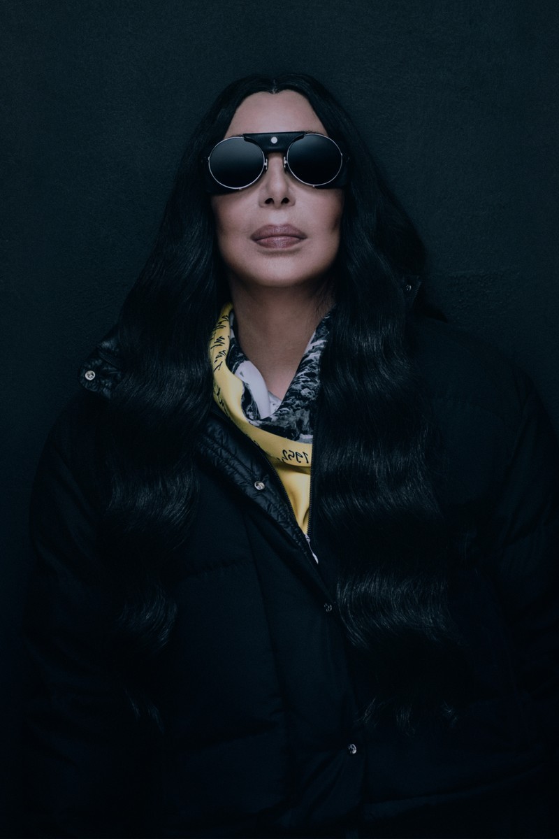 Moncler Re/Icons 2026, behind the scenes in black and white: Grace Jones in a glossy down jacket with the cast. 