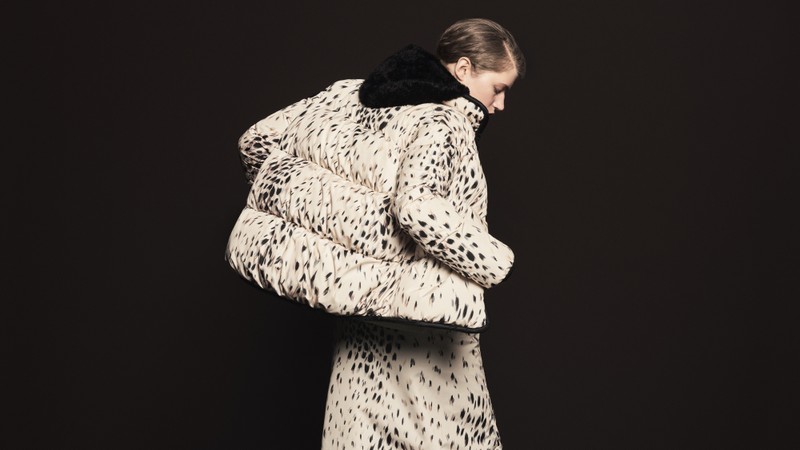 Moncler 2026年秋冬、ブラックのスポット柄が入ったクリーム色のダウンジャケット、お揃いのパンツとブラックのシアリングフード。 