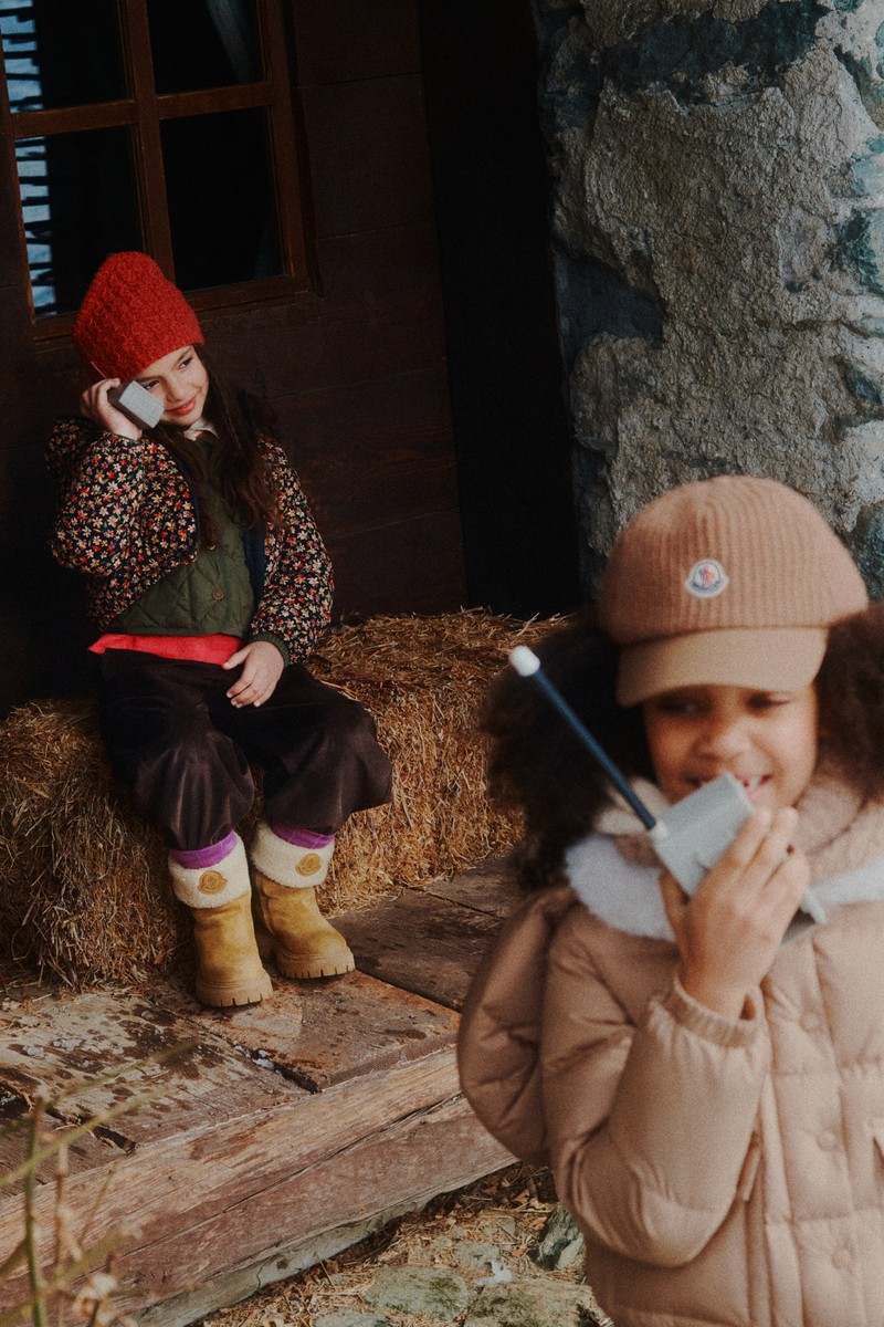 Moncler kids: brown down jacket, striped sweater, purple pants, logo beanie; beanie, green sweatshirt, blue down jacket.