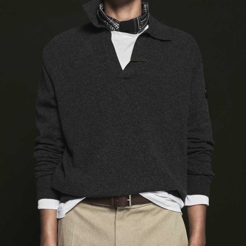 Moncler Pre-Fall 2026 男士系列：模特头戴酒红色针织帽，敞穿藏蓝色羽绒服，搭配浅蓝针织衫与细条纹短裤