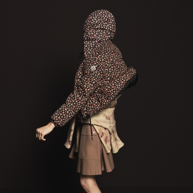 Moncler ウィメンズアウター。フローラルプリントのフード付きダウン、腰に巻いたベージュセーターとブラウンスカート(2)。