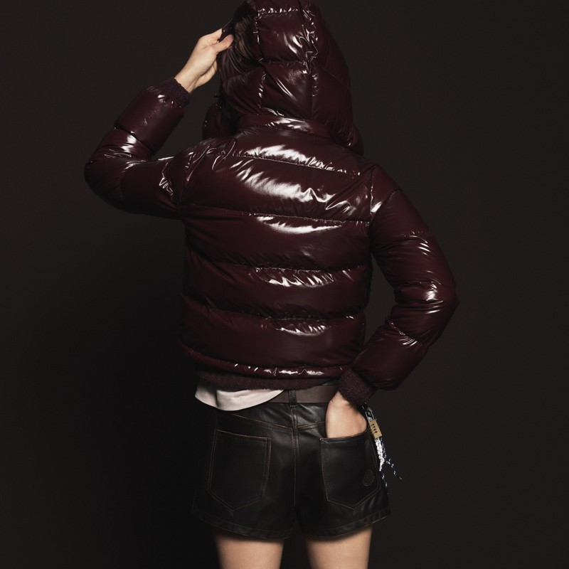 Capispalla Moncler donna. Piumino bordeaux lucido, t-shirt bianca e shorts in pelle. 