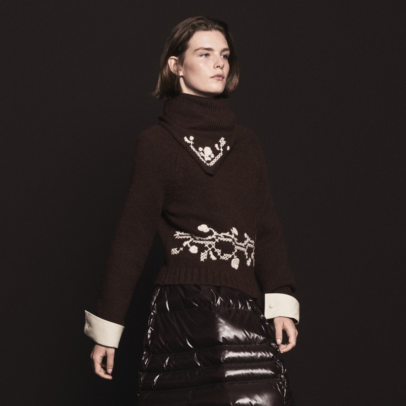 Moncler for women. Dark brown turtleneck sweater with cream floral motifs, white cuffs and glossy down skirt.