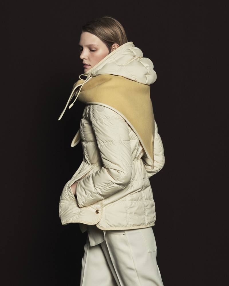Collection Moncler Pre-Fall 2026 : doudoune écrue, écharpe moutarde et pantalon écru.